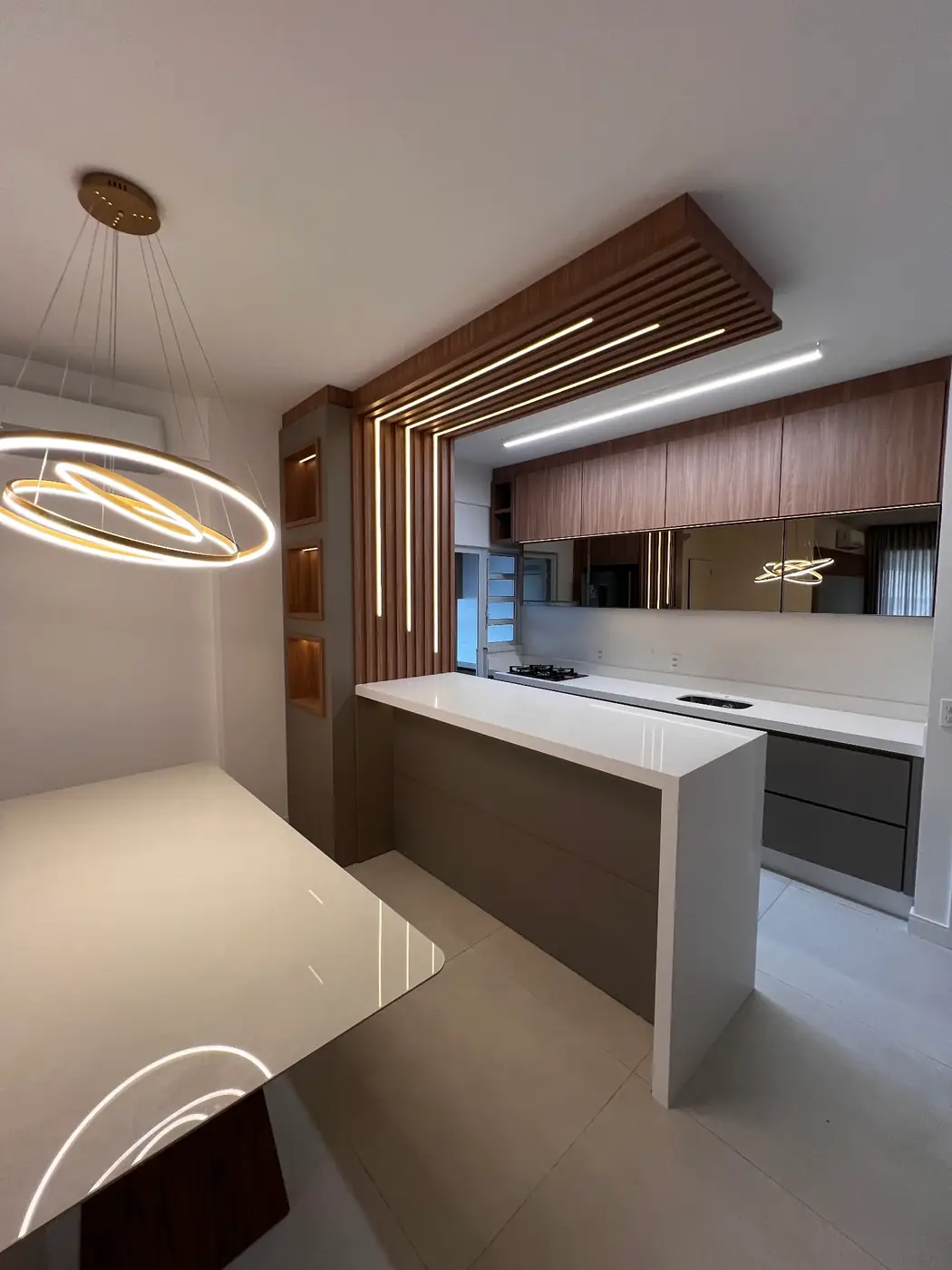Projeto entregue: cozinha com painel ripado iluminado e bancada branca