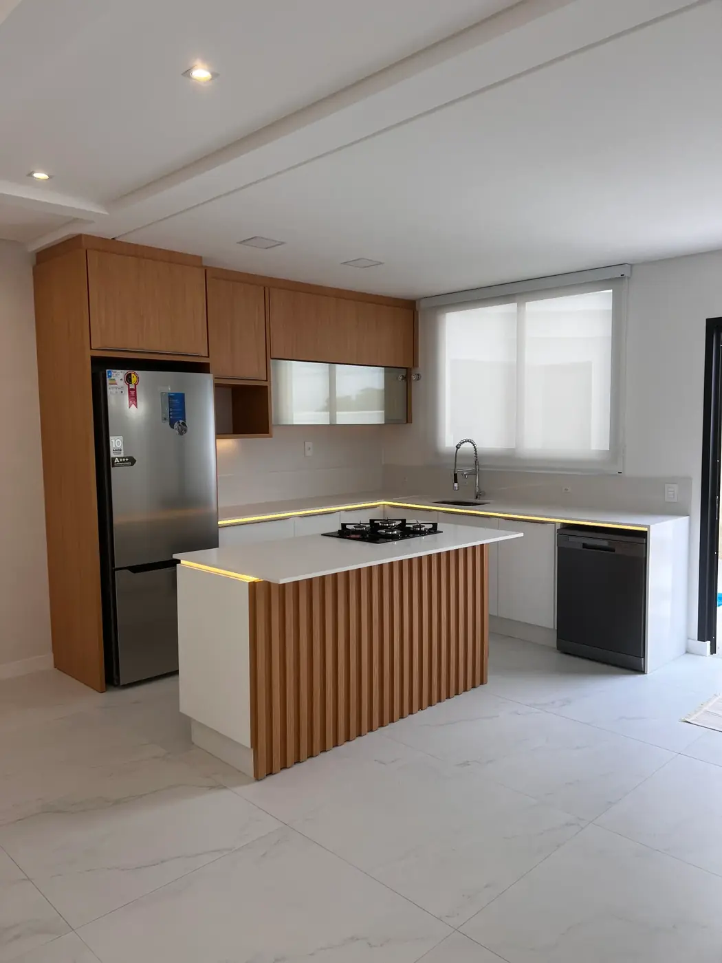 Projeto entregue: cozinha com ilha ripada em madeira e bancada branca
